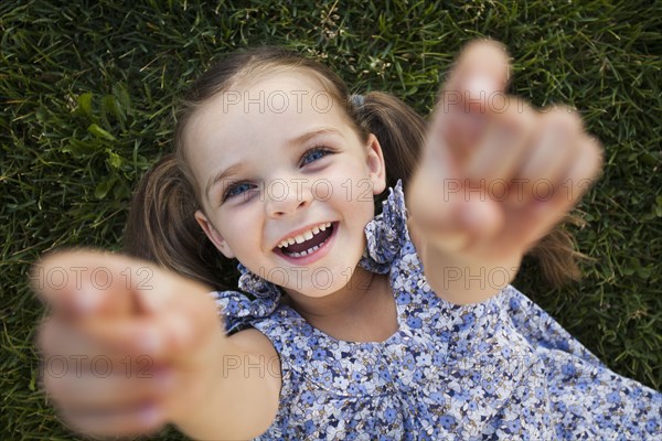 Caucasian girl playing in grass