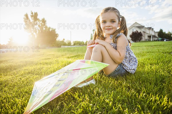 Caucasian girl with kite in grass