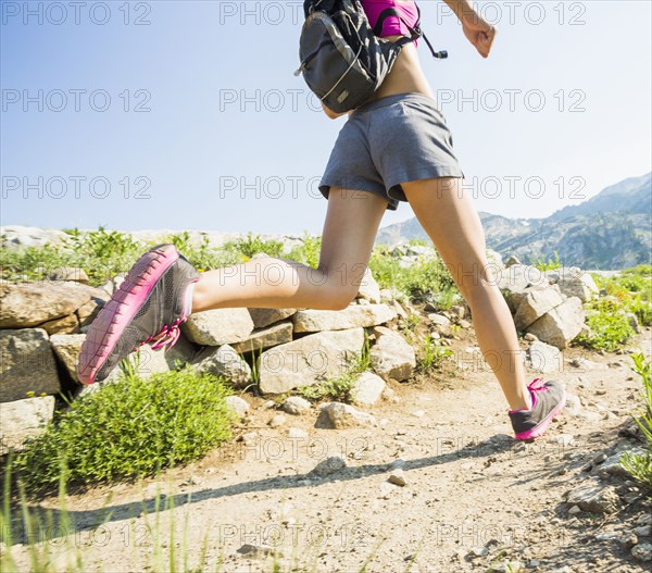 Caucasian woman running on rocky trail