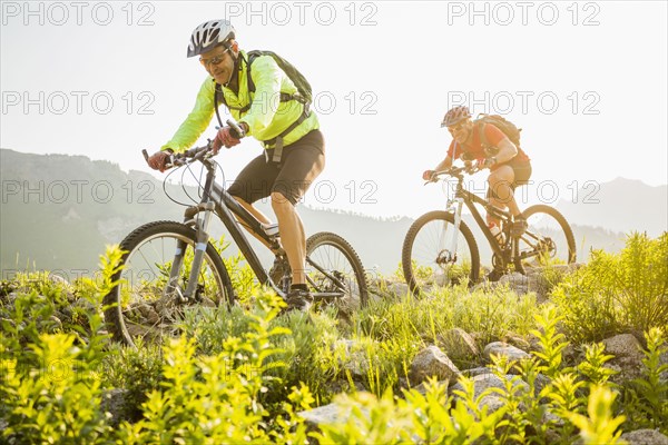 Caucasian men riding mountain bikes on trail