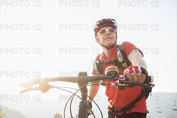 Caucasian man pushing mountain bike