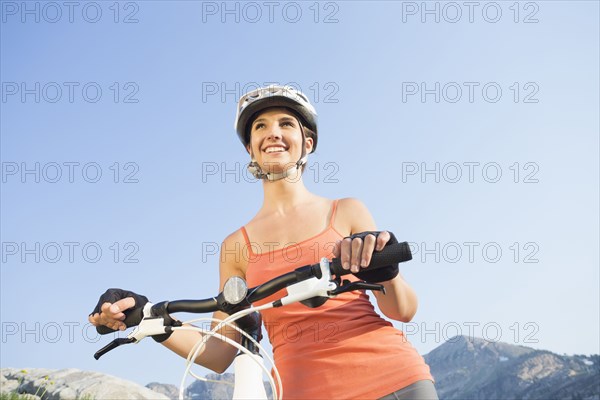 Caucasian woman pushing mountain bike