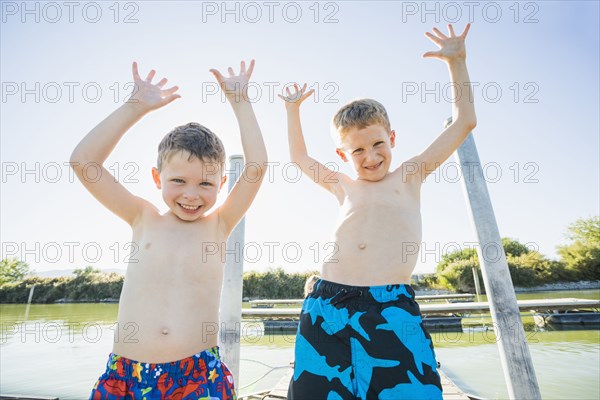 Caucasian boys playing by lake