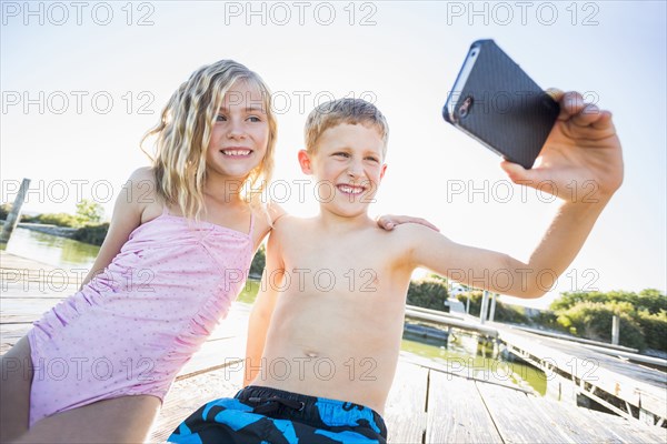 Caucasian children taking selfie with cell phone