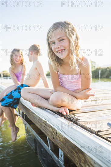 Caucasian girl sitting on dock