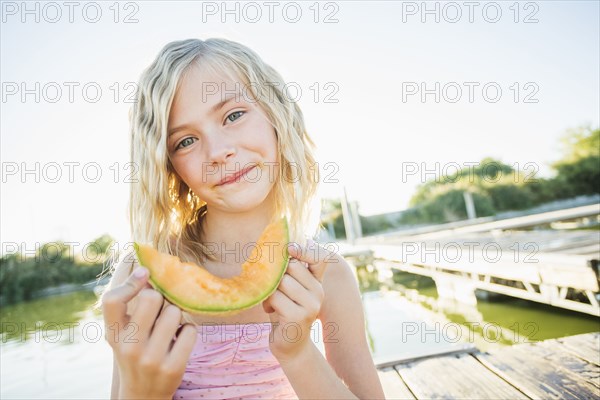 Caucasian girl eating cantaloupe slice