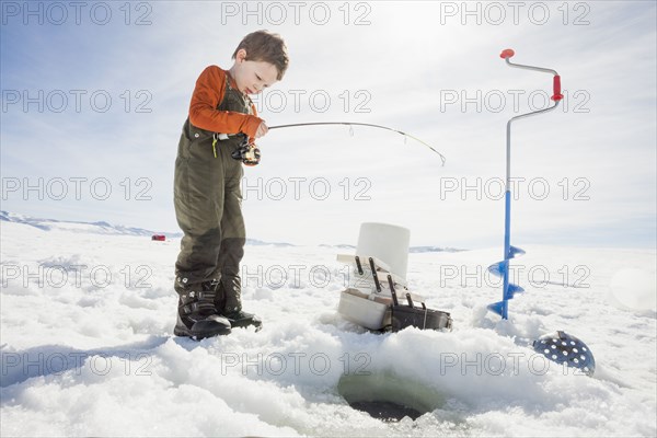 Caucasian boy ice fishing