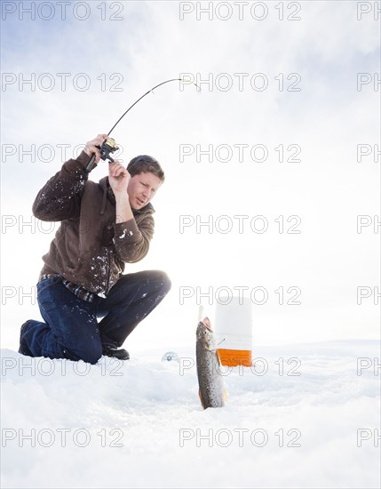 Caucasian man ice fishing