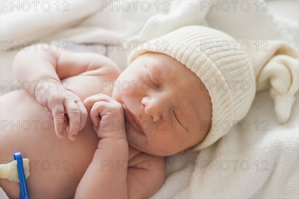 Caucasian newborn baby laying on blanket