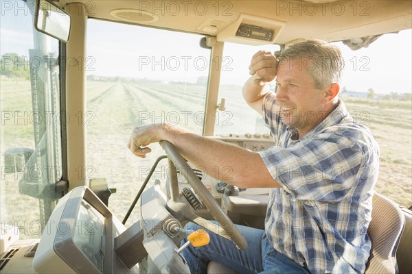 Caucasian farmer driving tractor