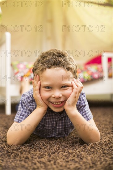 Caucasian boy smiling in bedroom