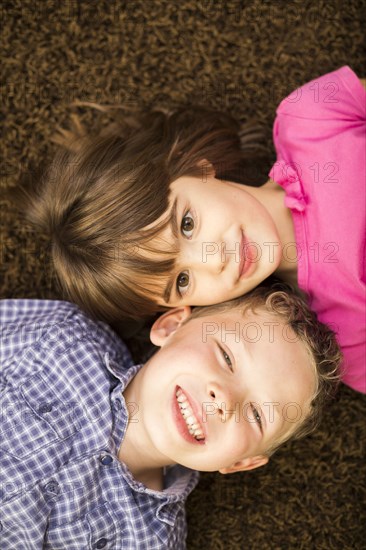 Caucasian children laying on carpet