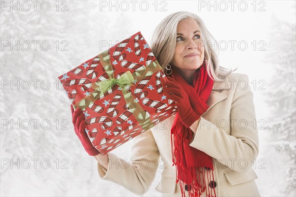 Caucasian woman shaking Christmas gift