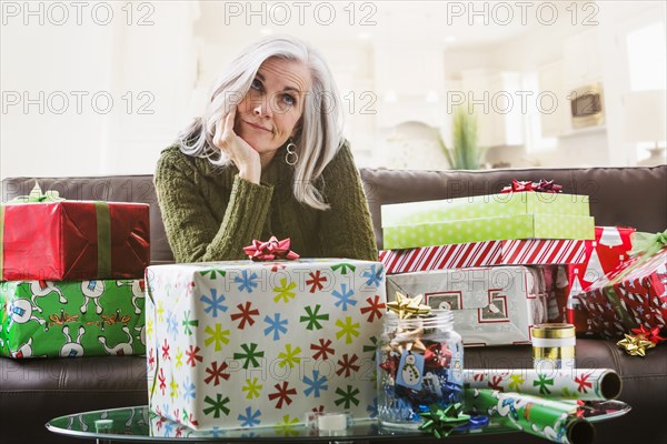 Irritated Caucasian woman wrapping Christmas gifts