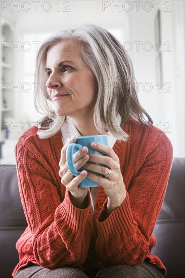 Pensive Caucasian woman drinking coffee