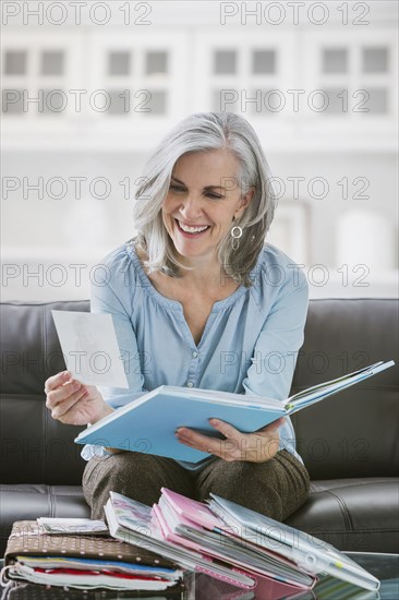 Smiling Caucasian woman looking at photograph albums