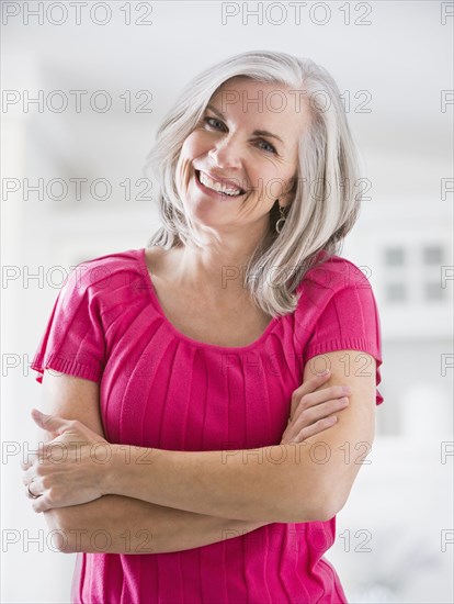 Portrait of smiling Caucasian woman with arms crossed
