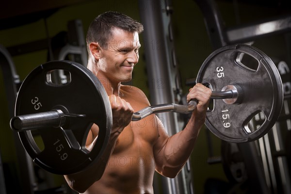 Caucasian man lifting barbell in gym