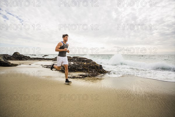 Caucasian man running on beach