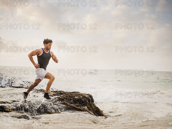 Caucasian man running on beach