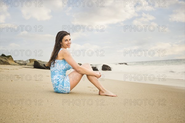 Caucasian woman sitting on beach