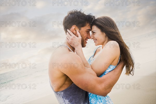 Caucasian couple hugging on beach