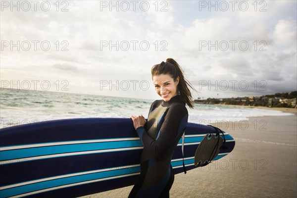 Caucasian surfer carrying board in surf