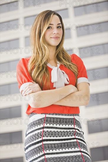 Mixed race businesswoman standing by window