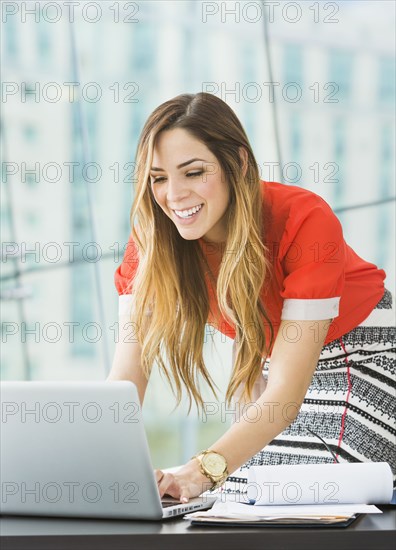 Mixed race businesswoman working at desk