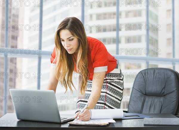 Mixed race businesswoman working at desk