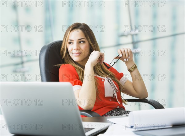 Mixed race businesswoman working at desk