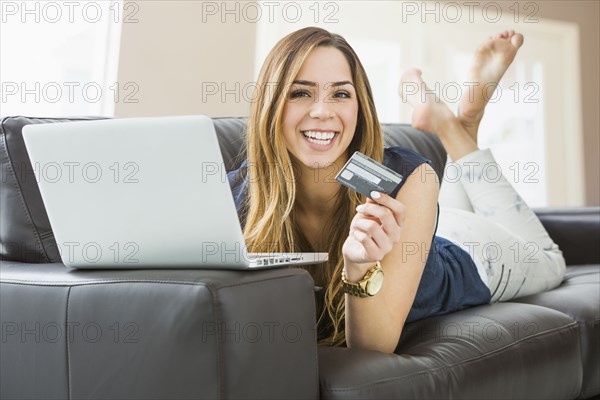 Mixed race woman shopping online on sofa