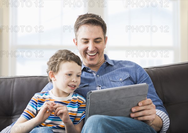 Caucasian father and son using tablet computer