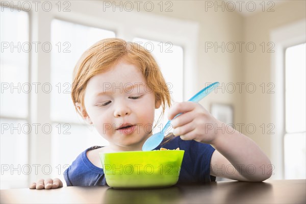 Caucasian girl eating at table