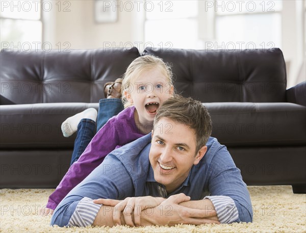 Caucasian father and daughter playing in living room