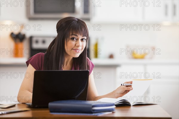 Hispanic businesswoman working at home