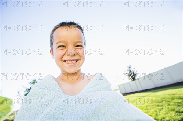 Caucasian boy playing with towel in backyard