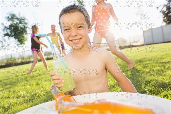 Caucasian boy drinking soda in backyard