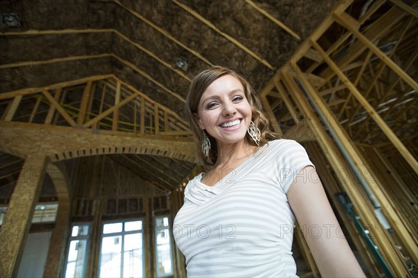 Caucasian woman smiling in house under construction