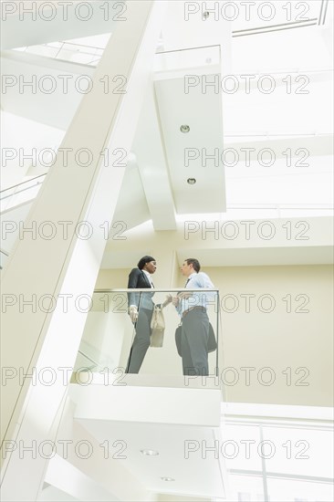 Low angle view of business people talking on office balcony