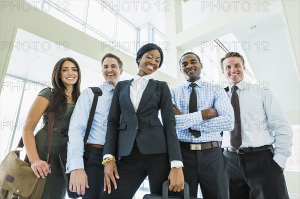 Low angle view of business people smiling in office lobby