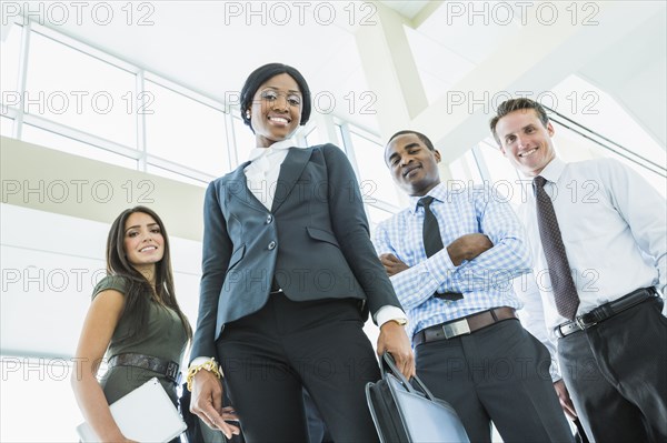 Low angle view of business people smiling in office lobby