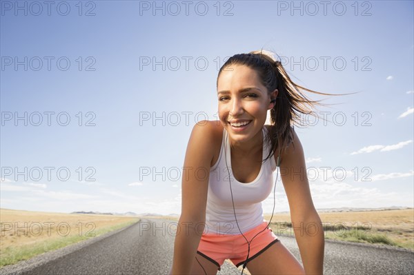 Caucasian runner resting on remoter road