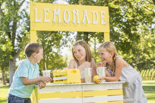 Caucasian children talking at lemonade stand