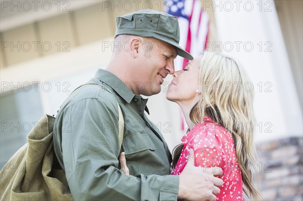 Returning Caucasian soldier hugging wife