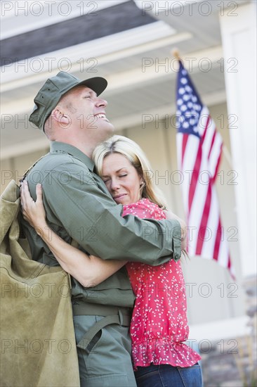 Returning Caucasian soldier hugging wife