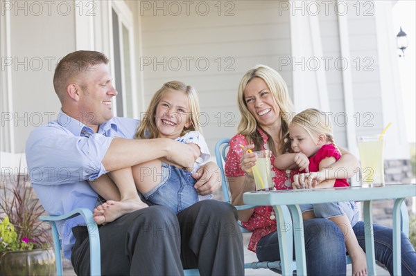 Caucasian family sitting on porch