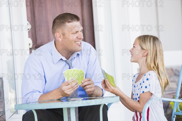 Caucasian father and daughter playing cards