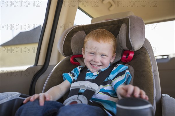 Caucasian boy smiling in car seat