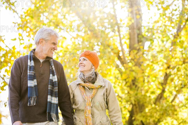 Older Caucasian couple walking near autumn trees